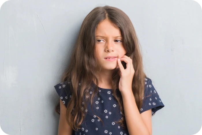 Enfant se tenant la joue à cause d'une douleur dentaire