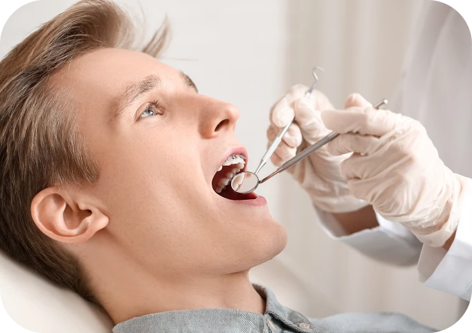Praticien examinant la bouche d'un patient lors d'une consultation d'orthodontie