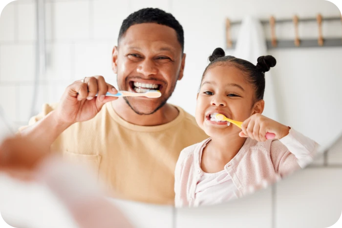 Enfant et parent se brossant les dents
