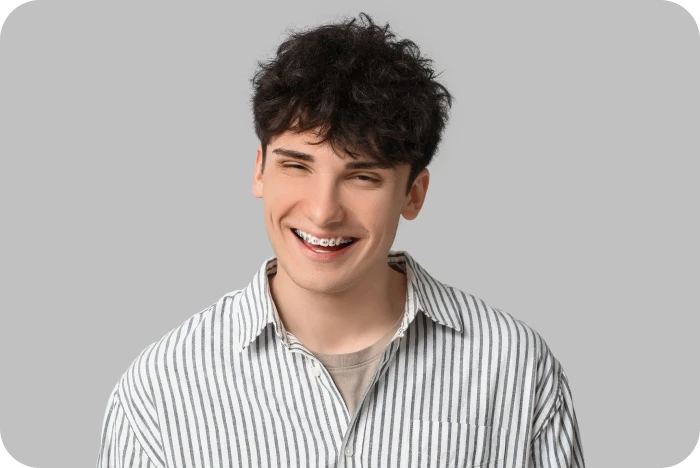 Adolescent souriant portant un appareil dentaire métallique