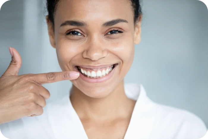 Femme souriante montrant ses dents alignées après un traitement orthodontique